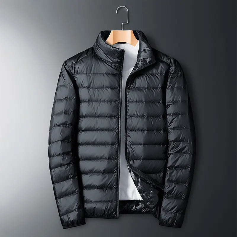 Men’s lightweight down jacket with a stand collar and storage feature; available in five colors; portable, compressible, warm, and highly puffy for autumn/winter; zippered outerwear; five-color stand-collar zippered portable travel outerwear for a...