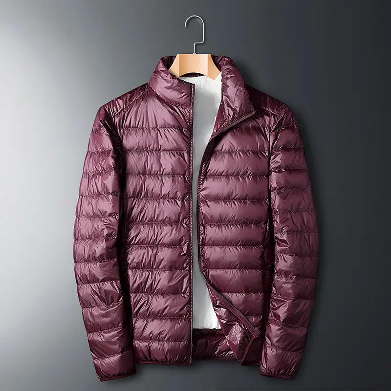 Men’s lightweight down jacket with a stand collar and storage feature; available in five colors; portable, compressible, warm, and highly puffy for autumn/winter; zippered outerwear; five-color stand-collar zippered portable travel outerwear for a...