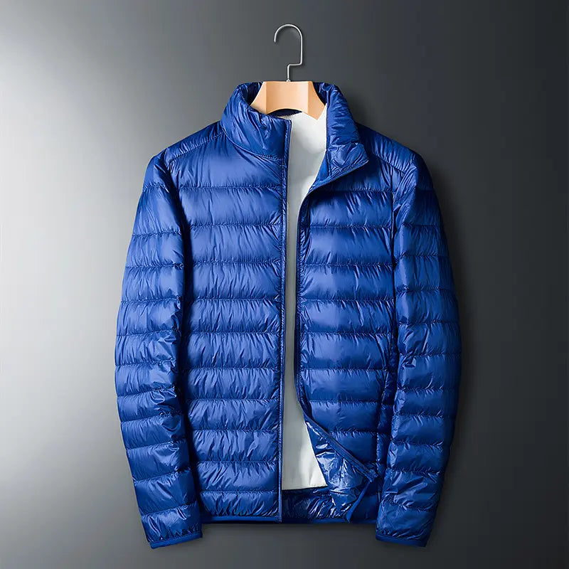 Men’s lightweight down jacket with a stand collar and storage feature; available in five colors; portable, compressible, warm, and highly puffy for autumn/winter; zippered outerwear; five-color stand-collar zippered portable travel outerwear for a...