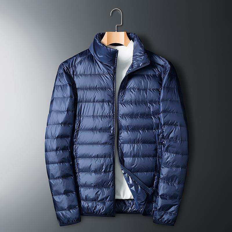 Men’s lightweight down jacket with a stand collar and storage feature; available in five colors; portable, compressible, warm, and highly puffy for autumn/winter; zippered outerwear; five-color stand-collar zippered portable travel outerwear for a...